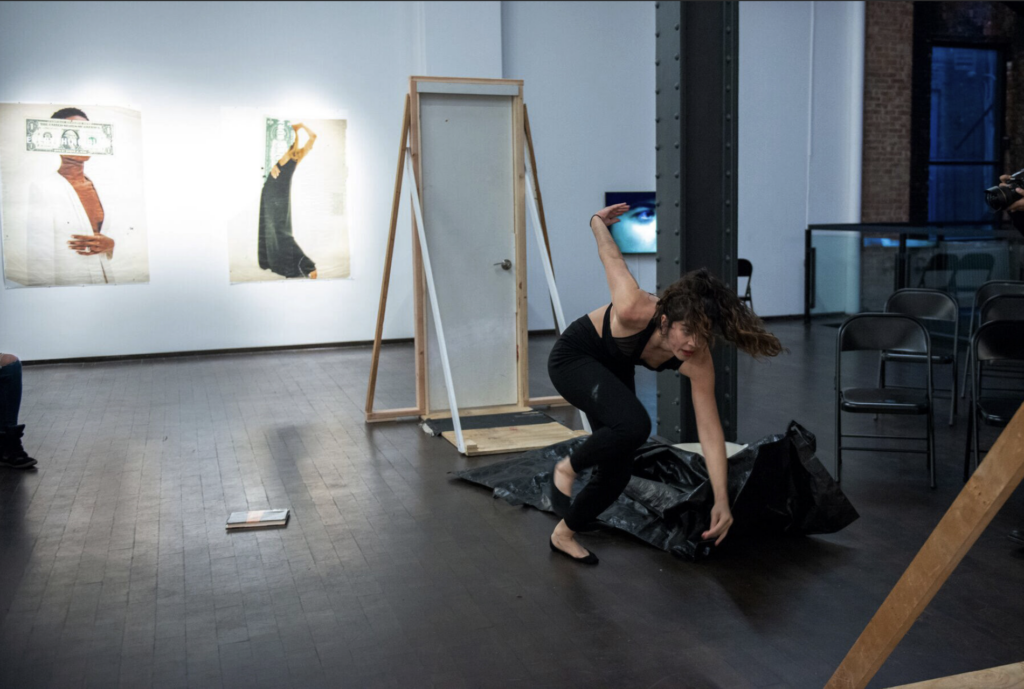 "Brown Hair Brown Eyes" Performance, where the artist escapes from a body bag in front of an audience. Photo: Courtesy of the Artist 
